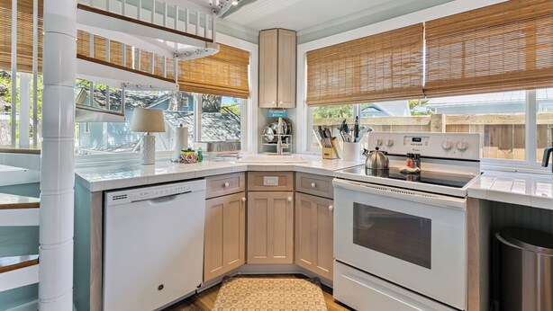 A modern kitchen with white appliances, wooden cabinets, and a built-in oven.