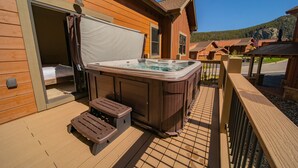 A wooden deck with a hot tub, a covered area, and a view of a mountain. - Scenic Keystone Retreat | Private Hot Tub (Keystone)