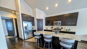 A modern kitchen with dark wooden cabinets, stainless steel appliances, and a granite countertop. - Scenic Keystone Retreat | Private Hot Tub (Keystone)