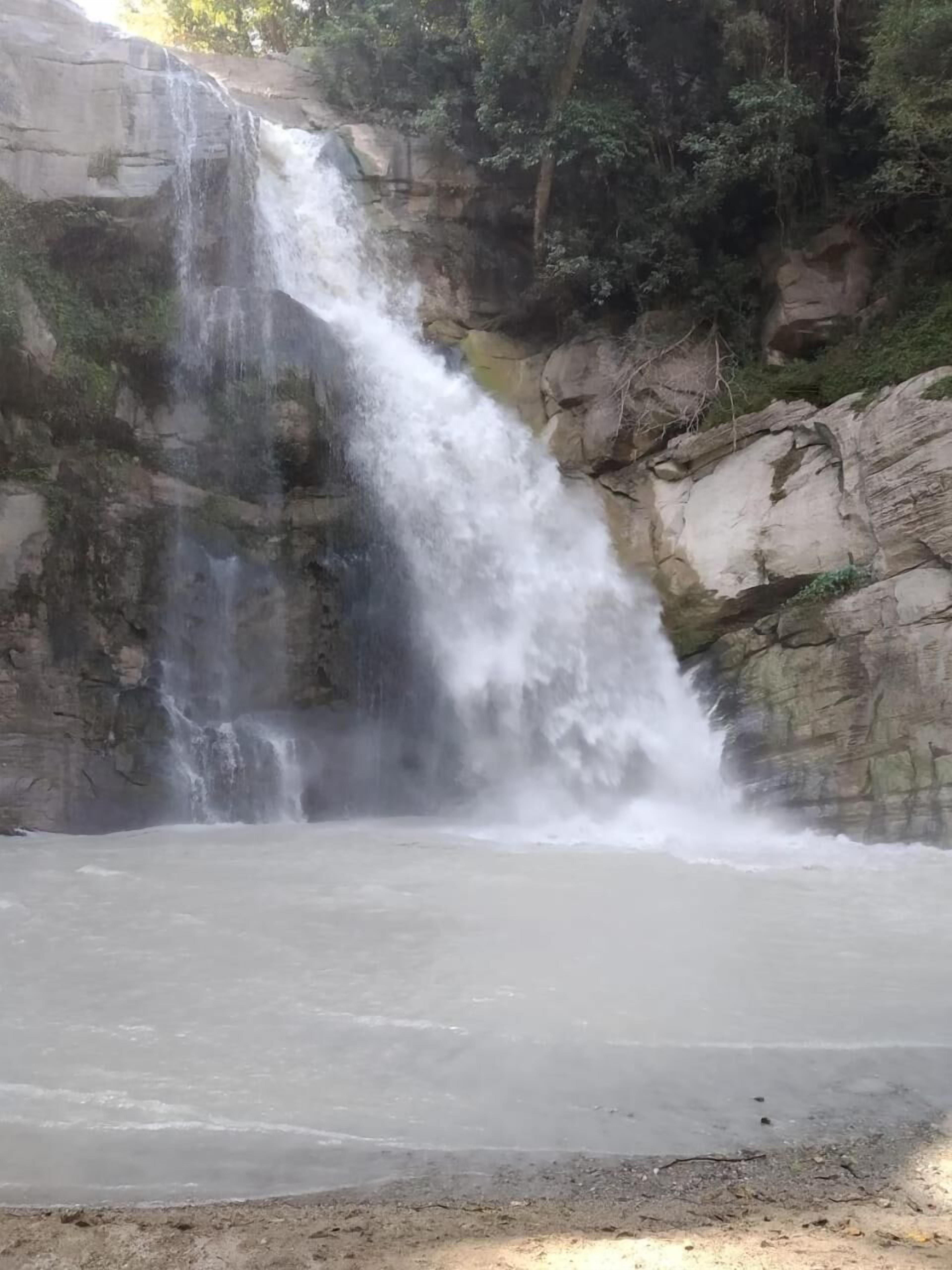 A waterfall cascading down a rocky cliff into a calm pool.