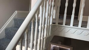 Un escalier avec des balustrades blanches menant à un palier.