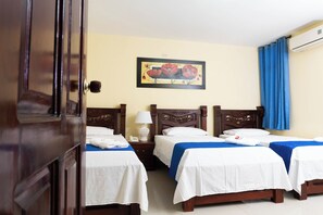 A hotel room with two single beds, a wooden headboard, a nightstand with a lamp, and a painting on the wall. - Hotel Arce Plaza (Valledupar)