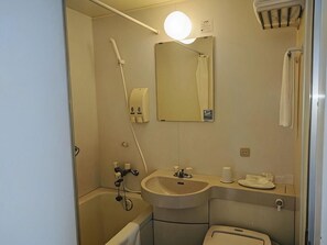 Un baño pequeño con lavamanos, espejo, toallero y zona de ducha.