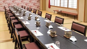 A conference room with a long table, chairs, and nameplates. - Daionji Onsen Banshokaku (Fukui)
