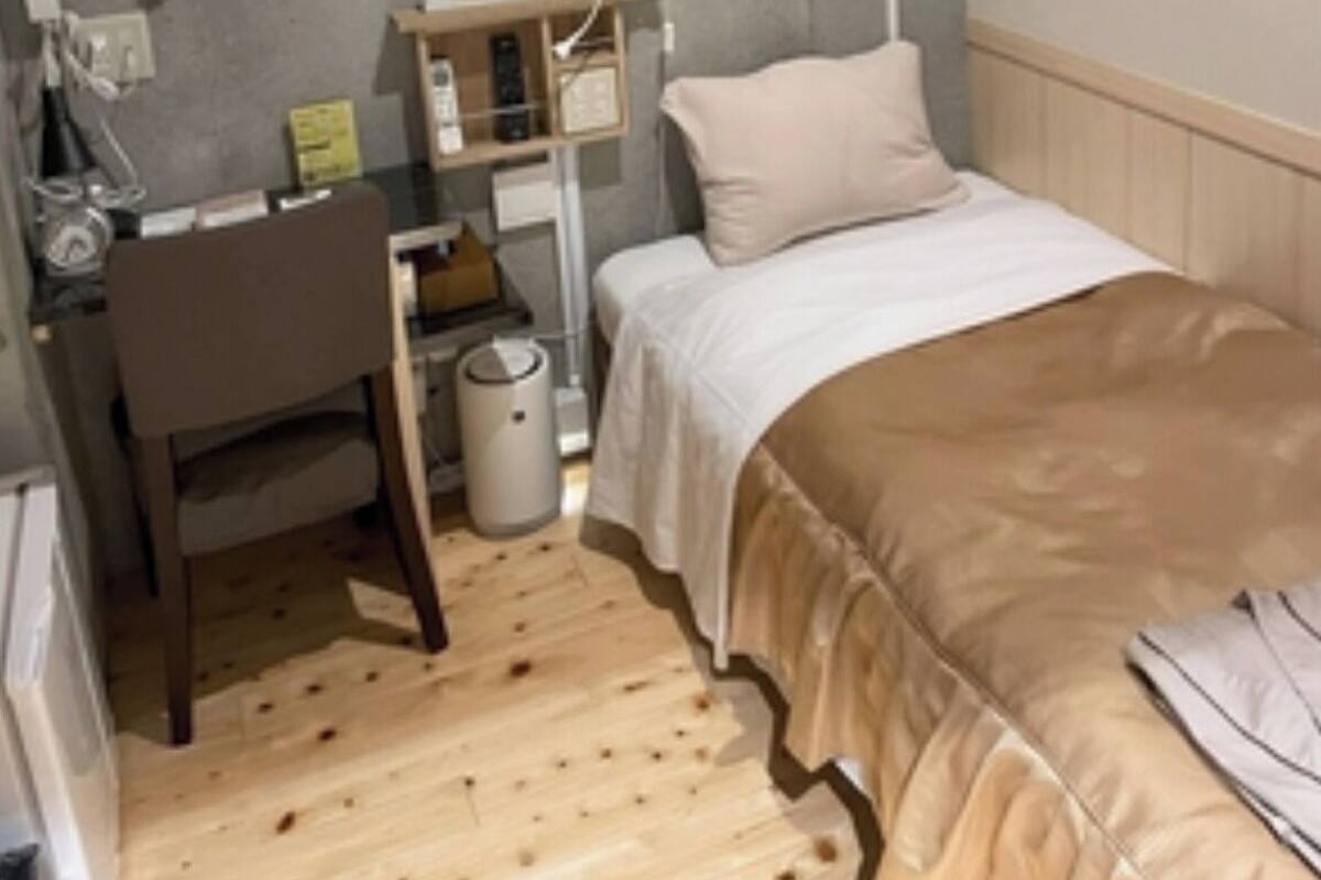 Ein gemütliches Schlafzimmer mit Bett, Schreibtisch und Stuhl.