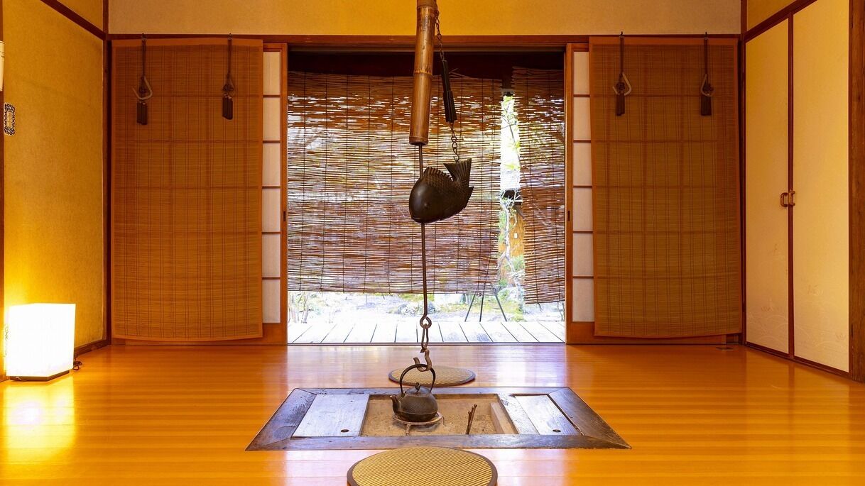 A traditional Japanese room with tatami flooring, sliding doors, and a hanging fish-shaped decoration.