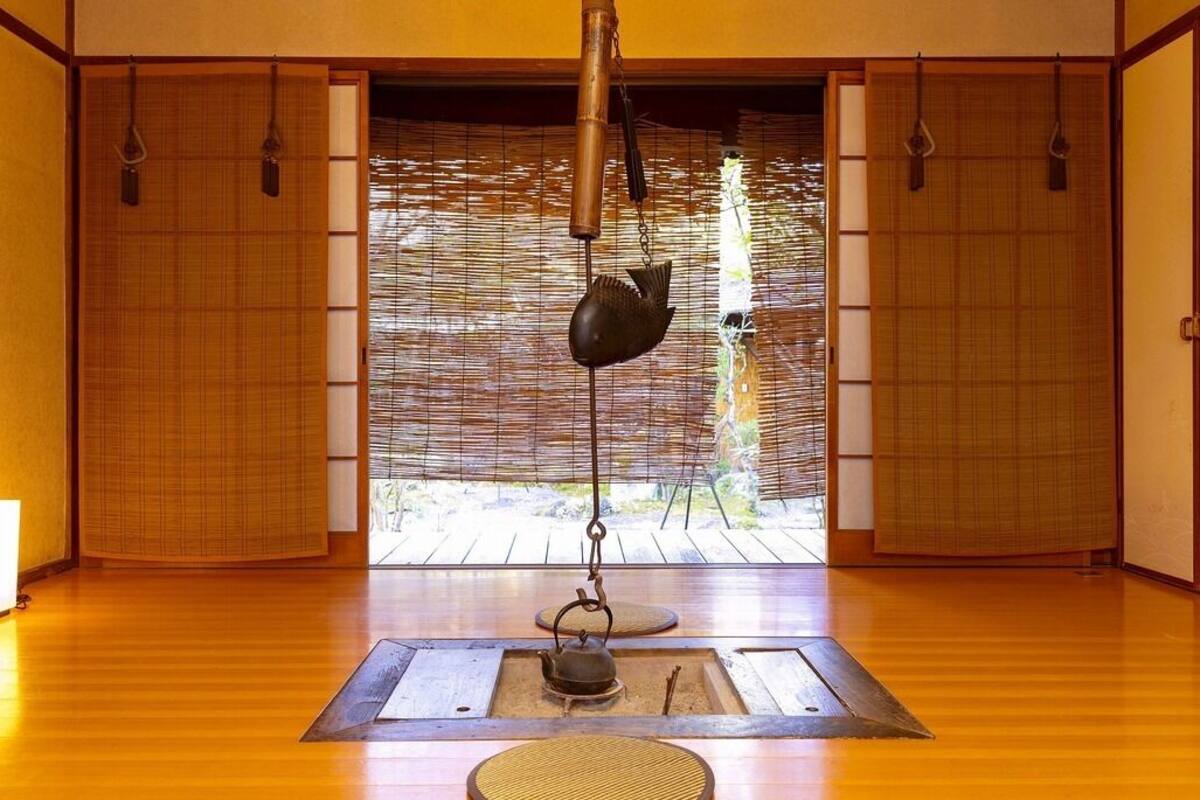 A traditional Japanese room with tatami flooring, sliding doors, and a hanging fish-shaped decoration.