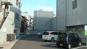 A parking lot with several cars parked, surrounded by buildings with a modern architectural style. - Imabari Plaza Hotel (Imabari)