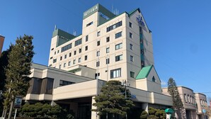 A multi-story hotel with a modern design, featuring a mix of rectangular and square windows, and a green roof. - Kuji Grand Hotel (Kuji)