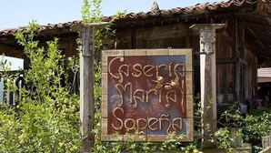 Een houten gebouw in rustieke stijl, met een bord waarop ‘Gasperia Maria Sopena’ staat.