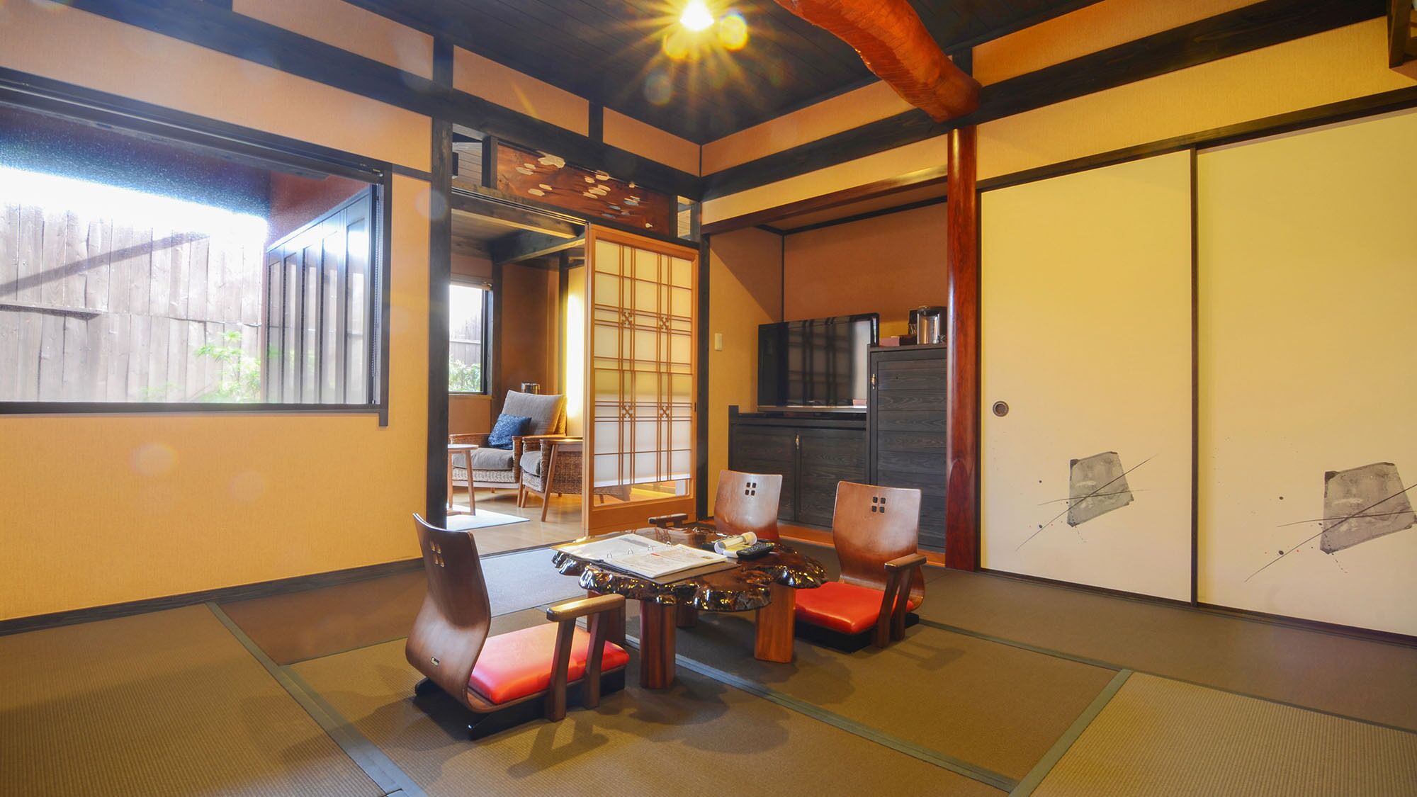 A traditional Japanese room with tatami flooring, a low table, and a sliding door.