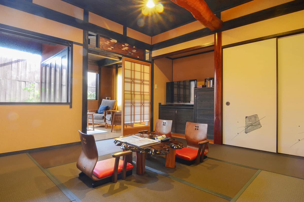 A traditional Japanese room with tatami flooring, a low table, and a sliding door.