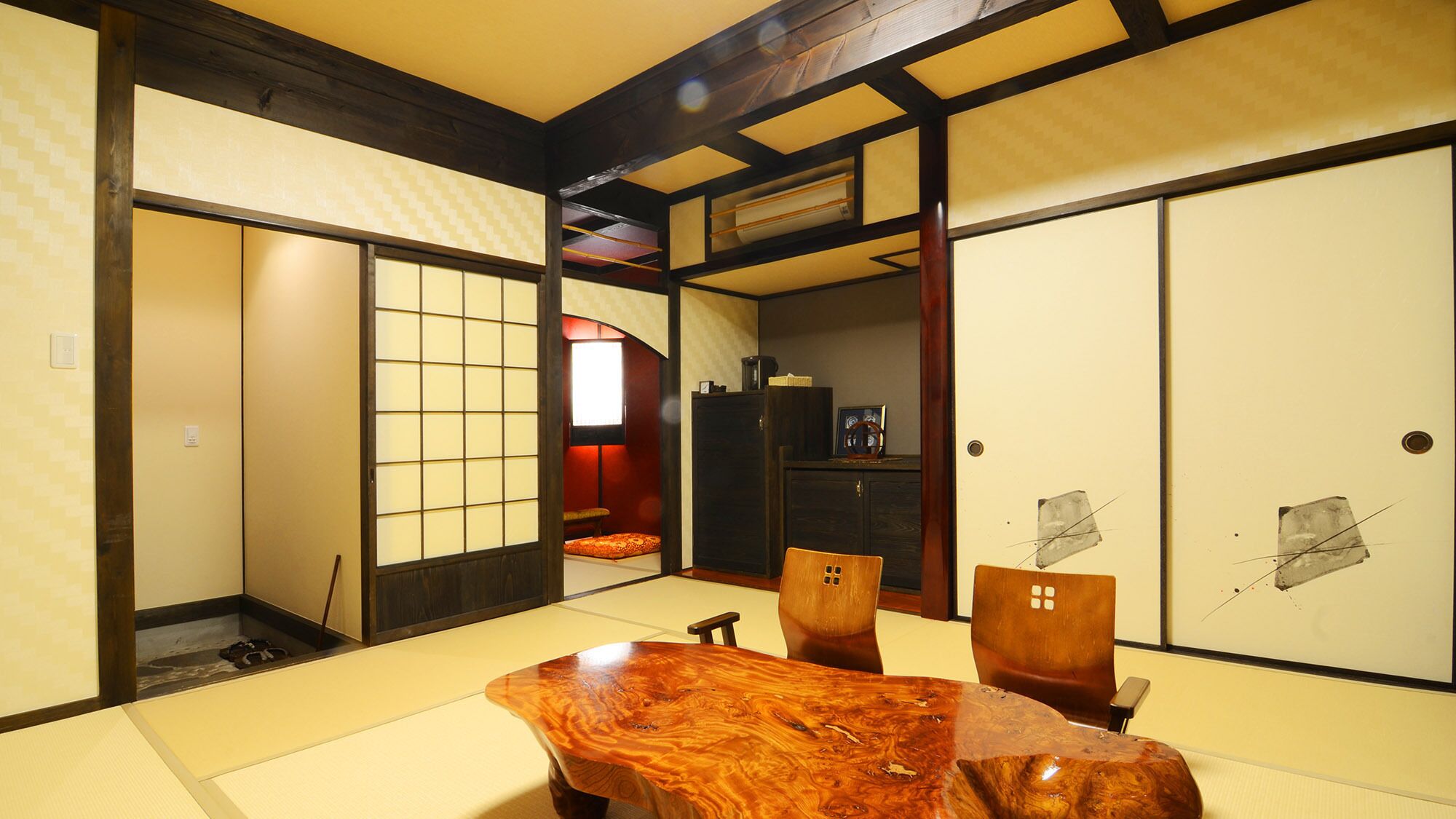 A traditional Japanese room with tatami flooring, a low wooden table, and sliding doors.