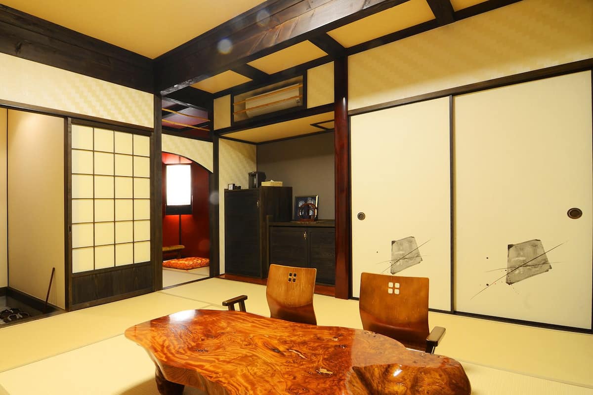 A traditional Japanese room with tatami flooring, a low wooden table, and sliding doors.
