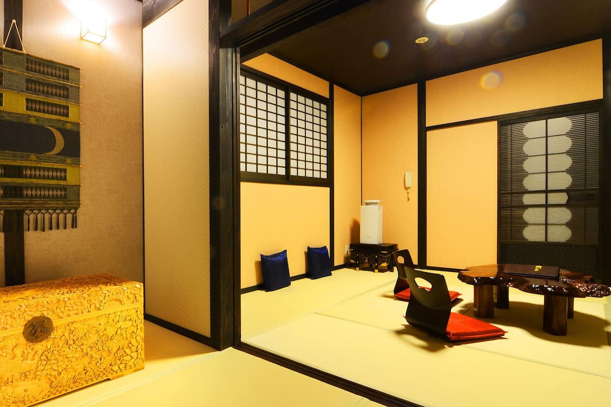 A traditional Japanese room with tatami flooring, a low wooden table, and a shoji screen.