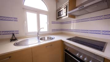 Full-sized fridge, microwave, stovetop, cookware/dishes/utensils