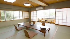 Een traditionele Japanse vergaderruimte met tatami vloerbedekking, een lage tafel en schuifdeuren.
