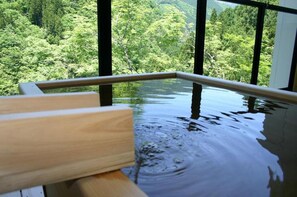 Eine hölzerne Bank an einem klaren Pool mit Blick auf einen Wald.