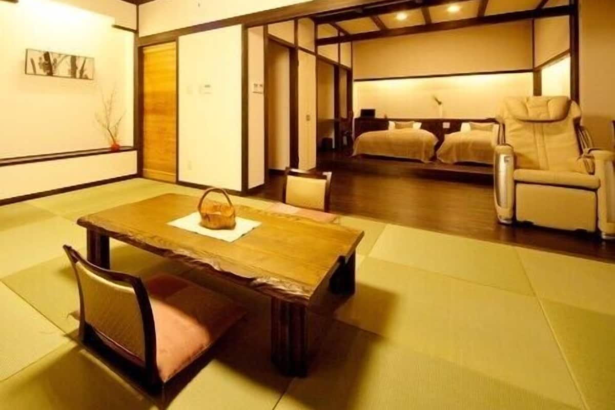 A traditional Japanese-style room with tatami flooring, a low wooden table, and a sofa.