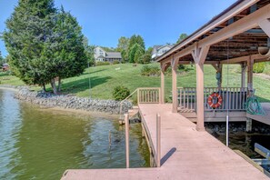 Relax by the serene lake with a tranquil dock and sheltered seating area amidst lush lawns and mature trees.