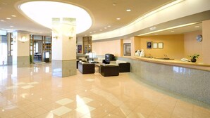 A hotel lobby with a reception desk, seating area, and a large circular light fixture. - Hotel Marine Palace Sanuki (Takamatsu)