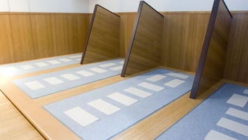 A tatami mat room with wooden partitions and a low wooden wall.