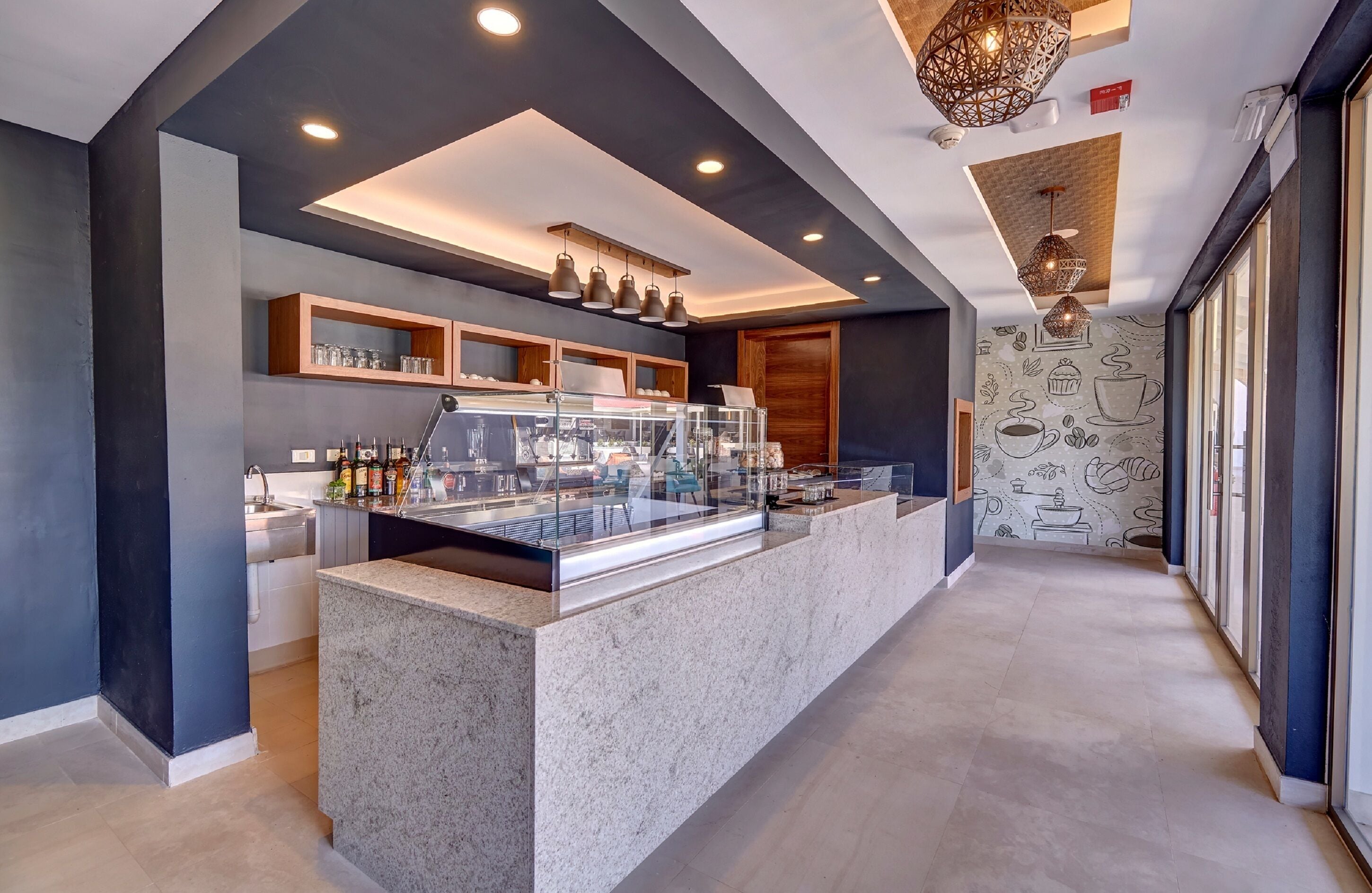 A modern kitchen with a central island, built-in shelves, and pendant lighting.