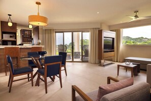 A modern living room with a dining area, a TV, and a balcony with a view.
