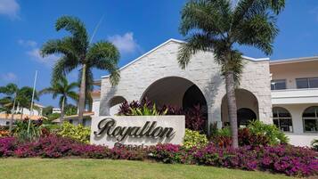 Ein Hotel Eingang mit einem Schild, das 'Royalton Grenada' zeigt, umgeben von üppiger Vegetation und Palmen.