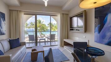 Una habitación de hotel moderna con balcón, sofá, mesa de comedor y televisor.