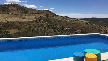 Een buitenzwembad en ligstoelen