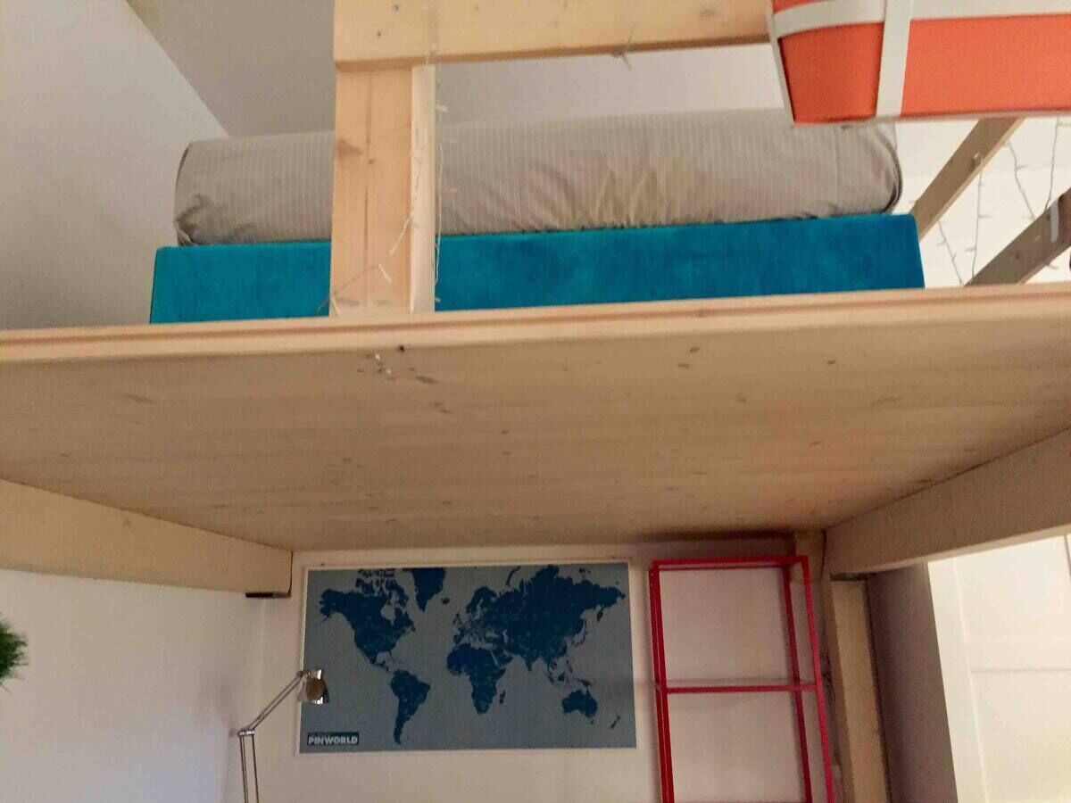A bunk bed with a world map on the wall below.