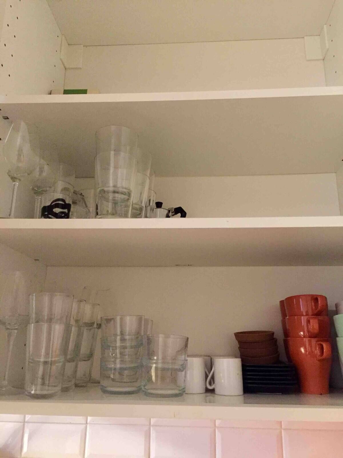 A shelf with various glassware and mugs.