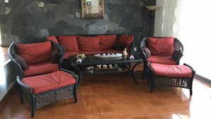 A living room with a stone wall, a sofa, two armchairs, and a coffee table. - GREAT HOUSE LA MAGDALENA TEQUISQUIAPAN (Magdalena)