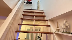Un escalier avec des marches en bois, un cœur décoratif et une sculpture d’oiseau.