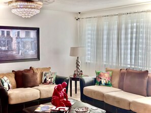 A living room with two sofas, a coffee table, a lamp, and a framed picture on the wall. - BLUE HOUSE (North Bay Village)