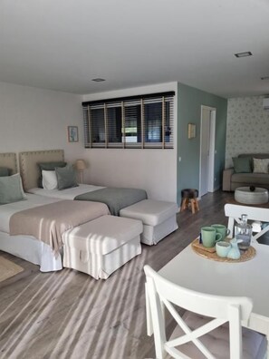 A bedroom with a bed, bedside table, and a window with blinds. - Quinta das Levadas Country House & Nature (Oliveira do Hospital)