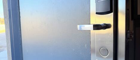Una puerta con lector de tarjeta de acceso y cerradura.