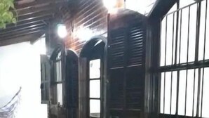A room with a checkered floor, wooden furniture, and large windows with bars. - Casa Aconchegante Lazer e Descanso (Araruama)