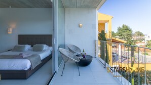 A modern bedroom with a bed, two chairs, and a small table with a bottle and glasses. - Barcares Suit, Villa 5StarsHome Mallorca (Alcúdia)