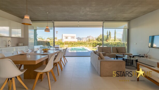 A modern kitchen with a dining area, a pool, and a living room with a sofa and coffee table. - Barcares Suit, Villa 5StarsHome Mallorca (Alcúdia)