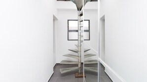 A spiral staircase with a central pole and glass steps in a white-walled hallway. - Eterna Primavera Adeje - Relax with Jacuzzi and A/C (adeje)