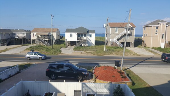 Une rue résidentielle bordée de maisons, avec une route et un ciel dégagé.