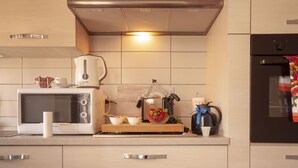 A modern kitchen with a microwave, kettle, and coffee maker on the counter.