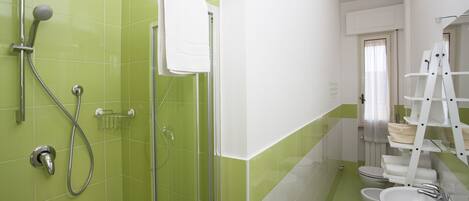 A bathroom with a shower, toilet, and sink.
