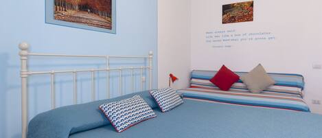 Un dormitorio con cama, almohadas, un cuadro en la pared y una cita.