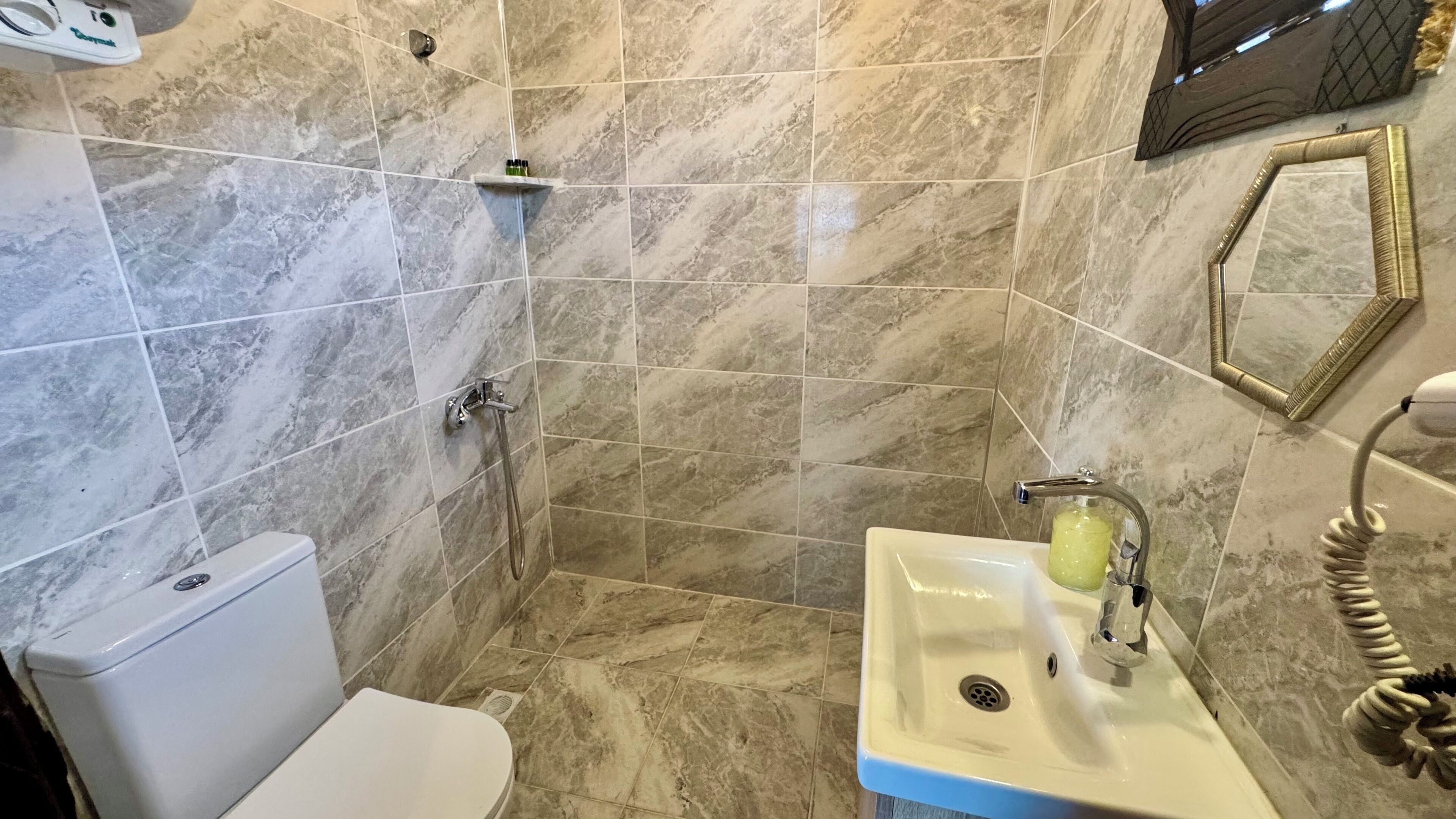 Un baño con inodoro, lavabo y ducha.