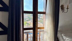 A room with a large wooden-framed window, curtains, and a wall-mounted light fixture. - Limaki Konak Sirince (Selçuk)