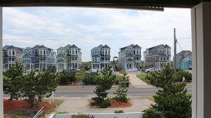 A view of a residential street with multiple two-story houses, a clear sky, and a few trees. - Sandbar Bed & Breakfast (Nags Head)