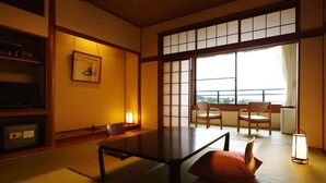 A traditional Japanese room with tatami flooring, a low table, and sliding doors. - Hotel Hisagoso (Shibata)